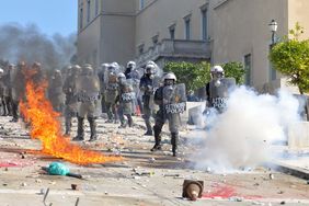 希腊防暴警察被火焰和烟雾包围