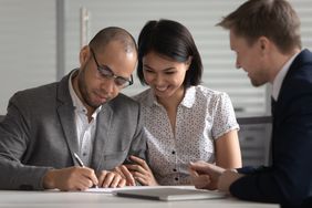 Couple signing paperwork with a banker