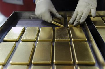 在澳大利亚的一家造币厂，一名员工正在整理一公斤的金条。
