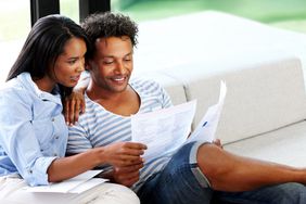 年轻夫妇在家阅读财务和税务工作。