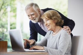 一对老年夫妇在家里用电脑。