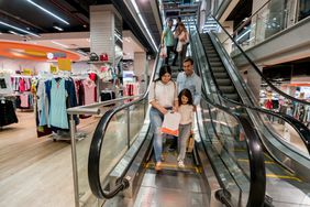 家人走自动扶梯在购物中心