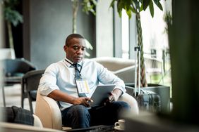 Person using a tablet while sitting in a hotel lobby