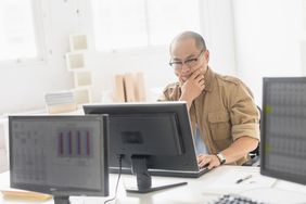一位男性老板坐在电脑前看财务报表