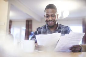 A taxpayer calculates his effective tax rate at home table with papers in hand