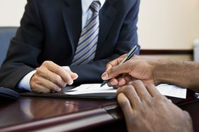 客户在银行经理处签署开立商业帐户的文件。