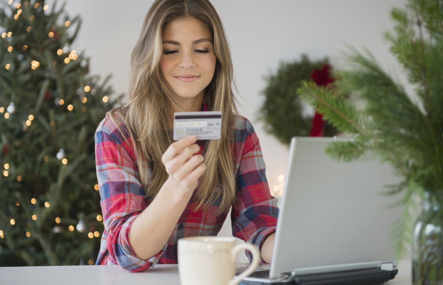 年轻女子在网上购物时使用信用卡