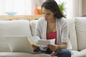 西班牙裔妇女用笔记本电脑在线支付账单