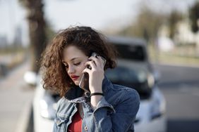 A driver calls their insurance company from the scene of an accident.