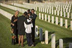 多代同堂的家人身着黑色衣服在军人公墓拥抱
