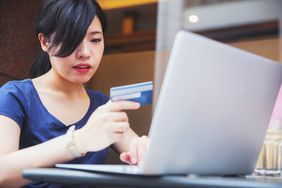 年轻的日本女子用她的信用卡在网上购物