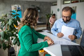 Bearded and bespectacled customer talking to a banker at the bank