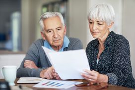 老夫妇看着他们的个人退休账户＂width=