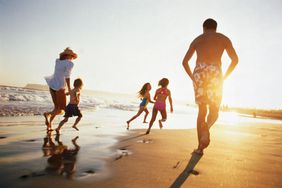 日落时分，一家人在沙滩上奔跑