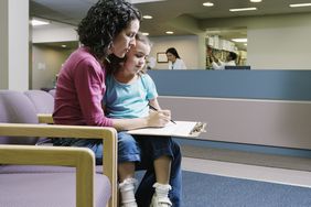 在医疗中心，女人在填表格，女孩(3-5岁)坐在膝盖上＂>
          </noscript>
         </div>
        </div>
       </div>
       <div class=