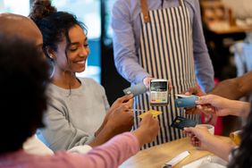 Group of friends paying with a credit card at a restaurant and splitting the bill