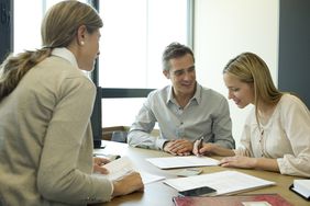 Two happy people signing contract at businesswoman’s desk