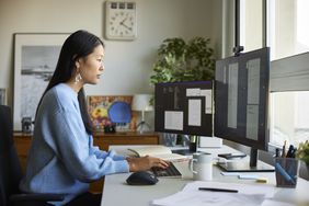 A person looks at computer screens.