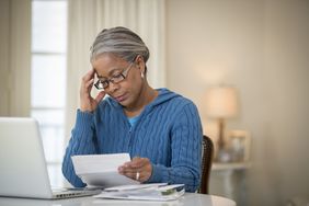 一位女士在查看有关她的401(k)计划的文件时看起来很担心。