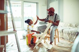 Parent and child sand a chair in a new home.