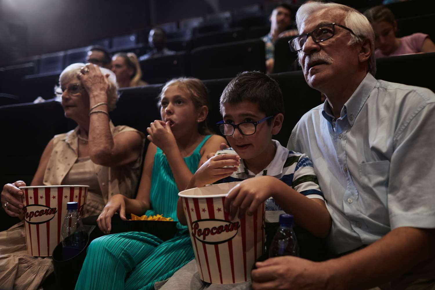 电影院重开,祖父母和孙子看电影。