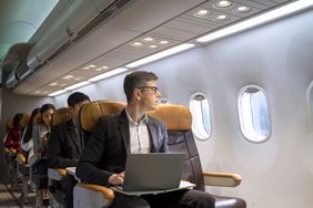 一名男子坐在飞机上，膝上放着笔记本电脑，望着窗外＂>
          </noscript>
         </div>
        </div>
       </div>
       <div class=