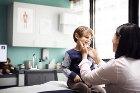 A doctor examines a child patient in a medical office