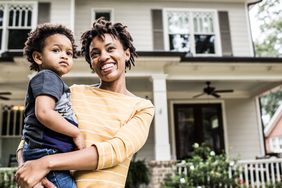 Parent and child in front of their home