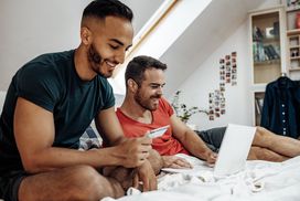 同性恋夫妇在家里使用互联网和笔记本电脑网上购物＂width=