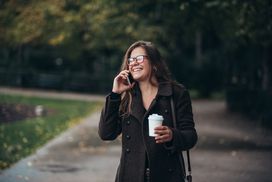 一个女人拿着手机走路。