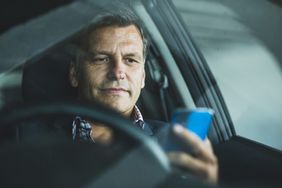 一个男人在车里看手机＂>
          </noscript>
         </div>
        </div>
       </div>
       <div class=