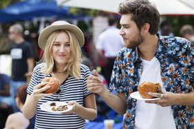 一对年轻的夫妇享受街头食品,另一个是不稳定的,在露天市场。