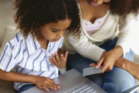 母亲和女儿用笔记本电脑在家购物＂width=