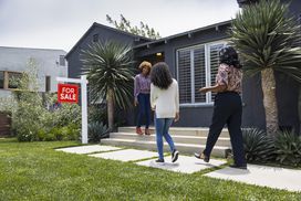 Real estate salesperson greeting customers while standing outside house