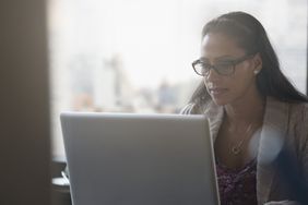 Focused person wearing glasses looking at a computer screen