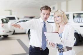 汽车销售人员向客户展示汽车，并与客户审查付款计划。＂>
          </noscript>
         </div>
        </div>
       </div>
       <div class=