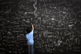 小男孩在黑板上写数学公式