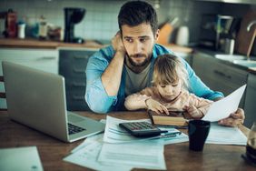 特写镜头:父亲和年幼的女儿坐在厨房桌子旁，手里拿着文件和笔记本电脑”>
          </noscript>
         </div>
        </div>
       </div>
       <div class=