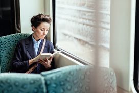 一个女人在火车上看书＂width=