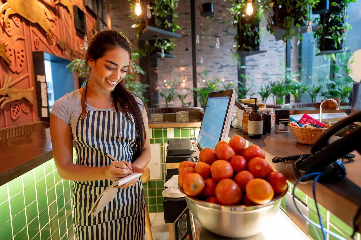 女人在一家餐馆工作重量在一碗西红柿面带微笑