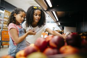 一个女人和一个孩子在超市挑选水果。