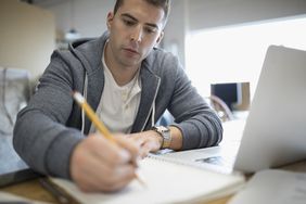 专注的创意商人在笔记本电脑上写作