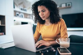 年轻的现代女性在家工作，在隔离期间使用笔记本电脑