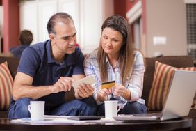 拉丁裔夫妇支付每月的账单在家里。”>
          </noscript>
         </div>
        </div>
       </div>
       <div class=