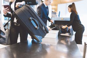 国际航班从机场安检机取回随身行李。