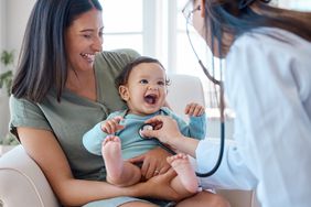一个婴儿坐在妈妈的腿上，医生通过听诊器听他们的心脏。＂>
          </noscript>
         </div>
        </div>
       </div>
       <div class=