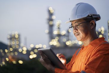 一位石油工人在轮班时检查生产数据。