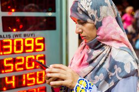 一名妇女在货币兑换亭前查看她的手机