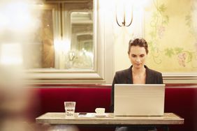 年轻的女商人在咖啡馆用笔记本电脑工作