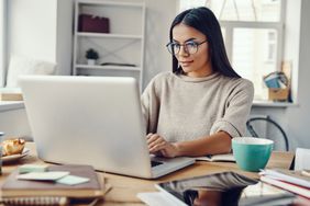 戴着眼镜的棕色长发女子正在看电脑